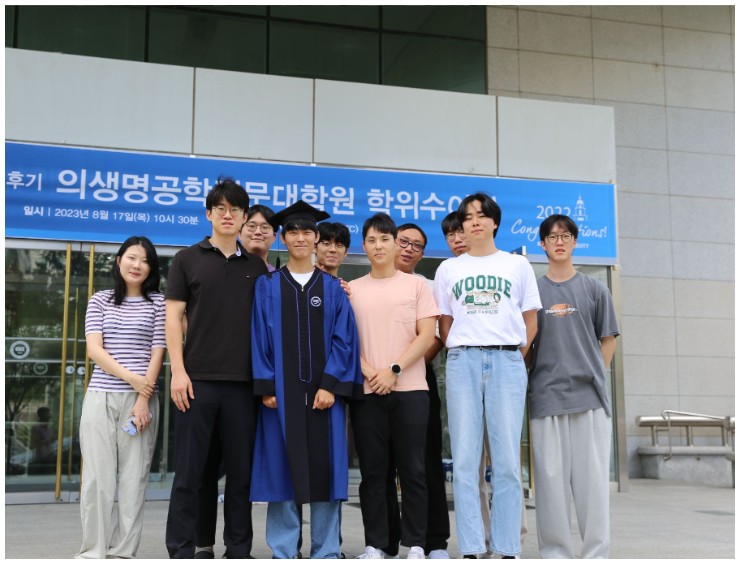 Graduation gown photo with lab members