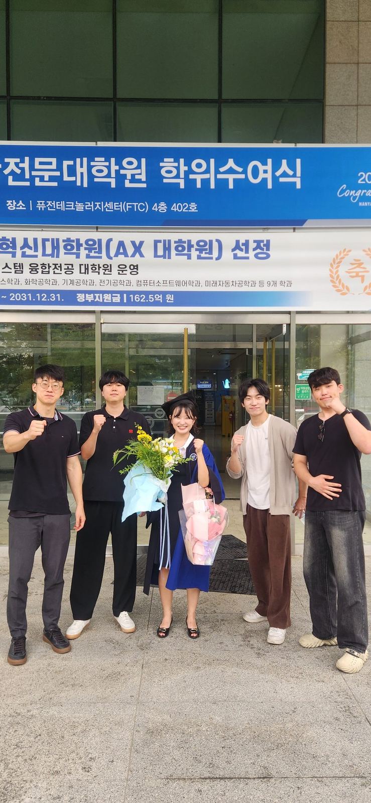 Serim Cho in graduation gown with lab members after the August 2026 ceremony